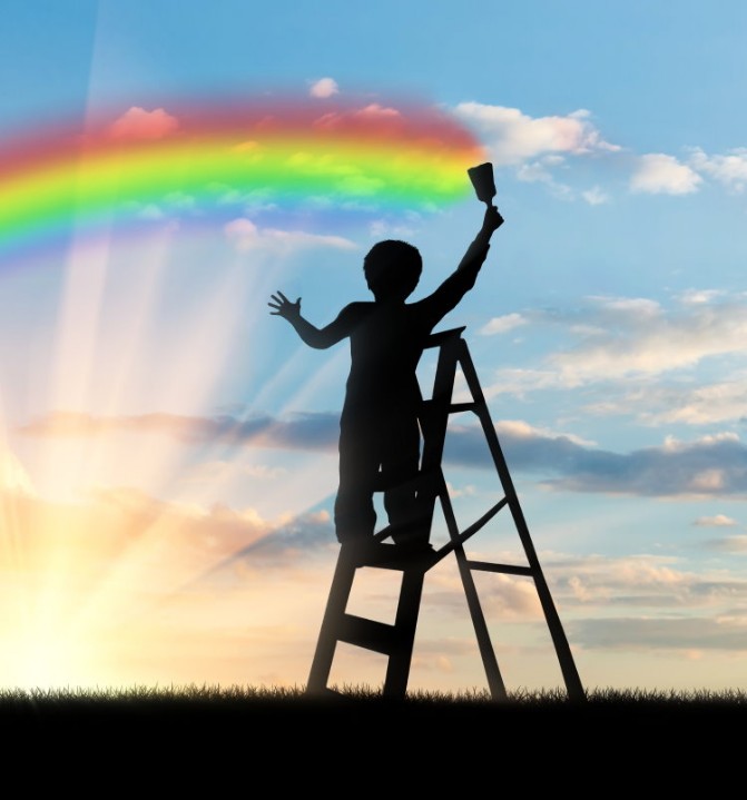 Boy painting a rainbow on the sky